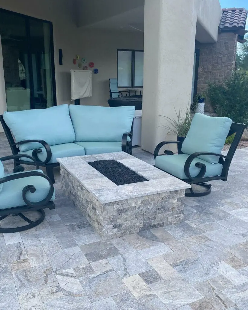 a patio with a fire pit and chairs